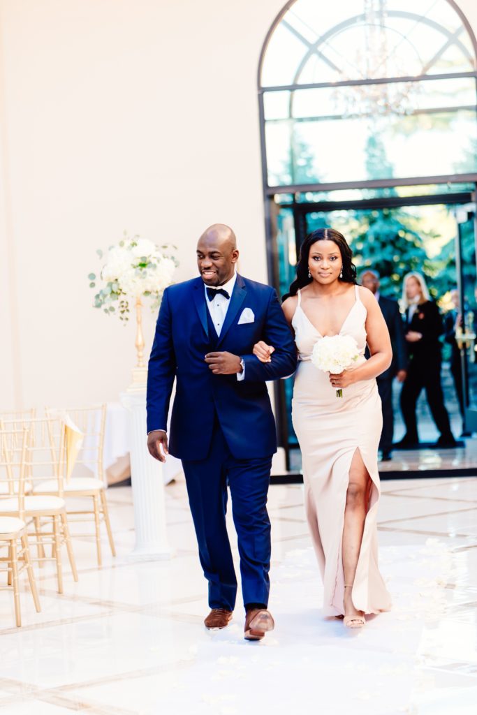 Ivoirian groomsman and Haitian bridesmaid walking down the aisle at the wedding ceremony