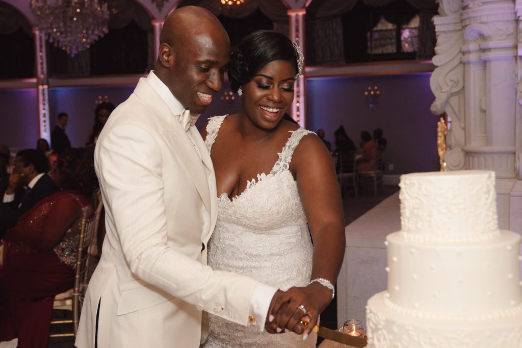 Ivoirian groom and Congolese bride cutting the cake at their wedding reception