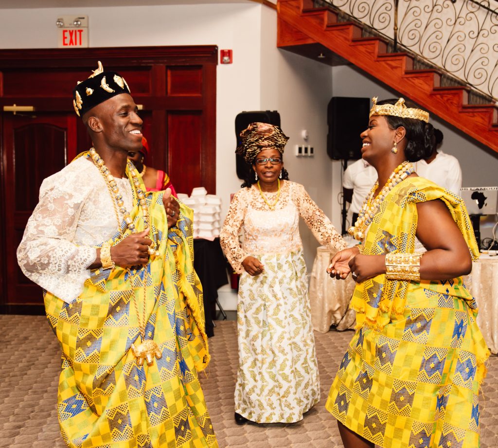 Ivoirian bride and groom at wedding reception in yellow traditional attire
